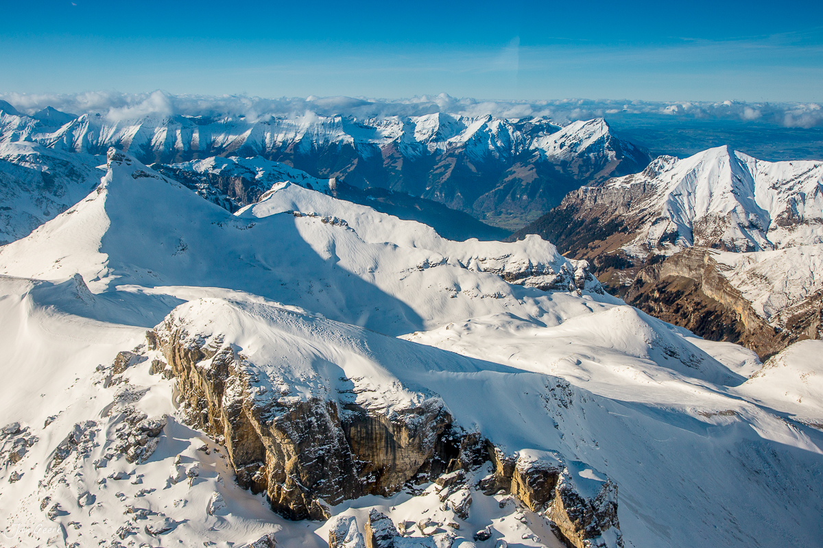 Schneebedeckte Berglandschaft mit verschneiten Gipfeln und Tälern in der Schweidegg, Berner Oberland, Schweiz – Jan Geerk Fotograf Basel