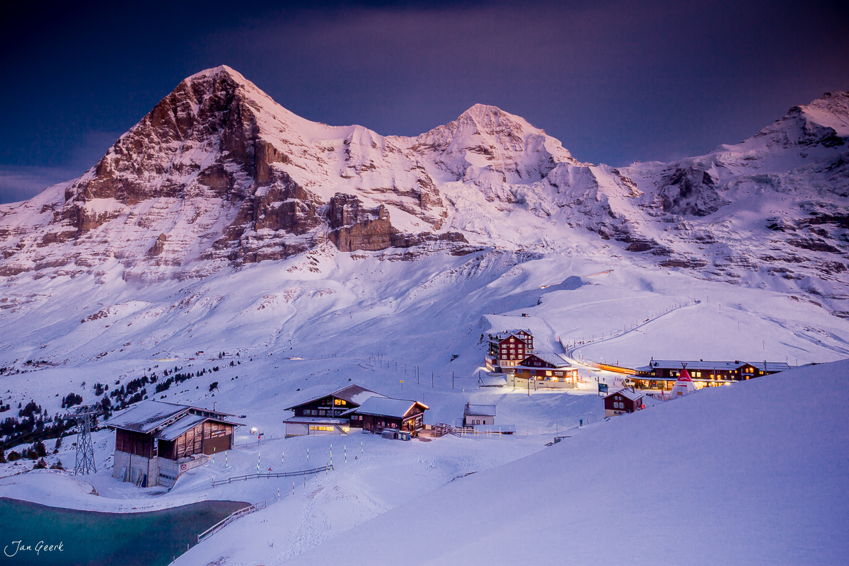 Schneebedecekte Berglandschaft mit beleuchteten Alphütten bei Scheidegg im Berner Oberland Schweiz – Jan Geerk Fotograf Basel