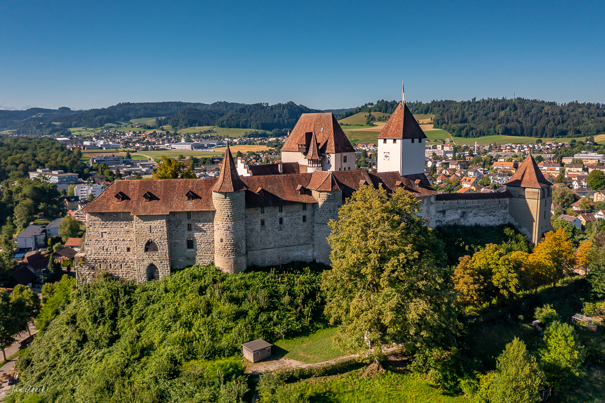 Schloss Burgdorf mit charakteristischen Türmen umgeben von grünem Wald in Sommerstimmung Emmental Schweiz Jan Geerk Fotograf Basel