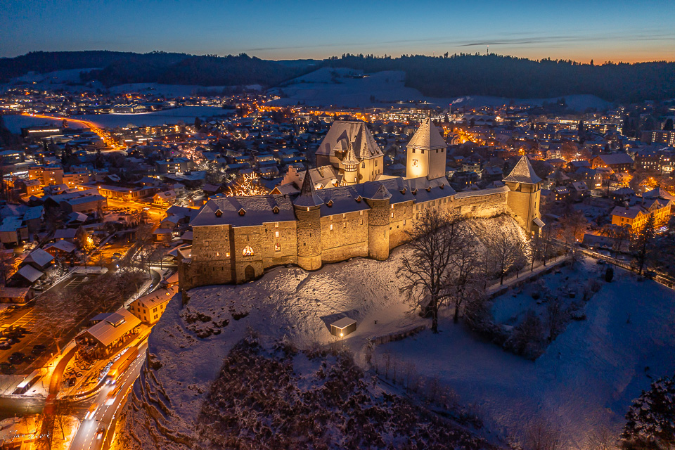 Schloss Burgdorf beleuchtet in Winternacht über verschneiter Landschaft Emmental Schweiz – Jan Geerk Fotograf Basel