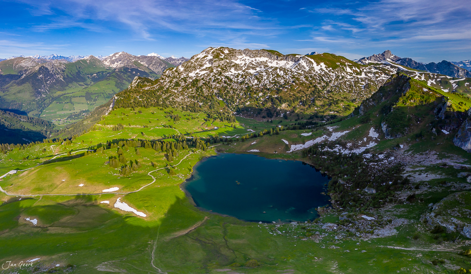 Alpiner Bergsee Seebergsee mit Schneebergen und grünen Alpenwiesen im Bergfrühling, Berner Oberland Schweiz – Jan Geerk Fotograf Basel