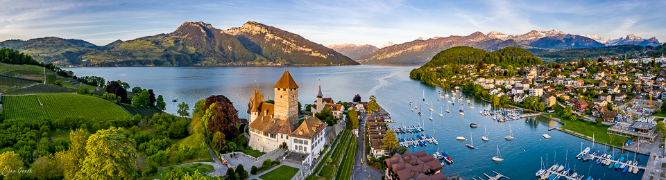 Schloss Spiez am Thunersee mit Rebbergen, Segelbooten und Alpenkulisse in goldenem Kantlicht, Berner Oberland Schweiz – Jan Geerk Fotograf Basel