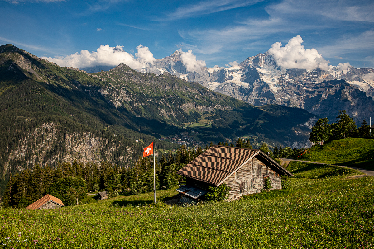 Alphütte mit Schweizer Flagge in Isenfluh, Berner Oberland, Sommermorgen mit Bergpanorama – Jan Geerk Fotograf Basel