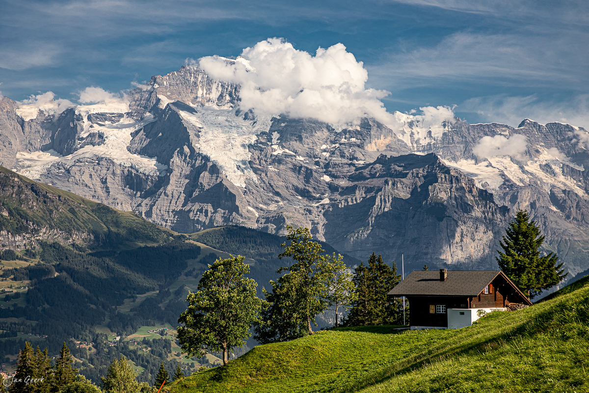Berghütte in Isenfluh mit Blick auf schneebedeckte Alpen, Jungfrau und Eiger, Sommer – Jan Geerk Fotograf Basel