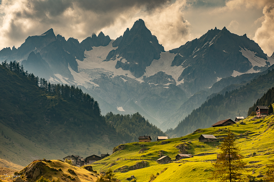 Alpendorf am Sustenpass mit grünen Bergweiden, schneebedeckten Gipfeln und Kantlicht im Sommer – Schweiz, Jan Geerk Fotograf Basel