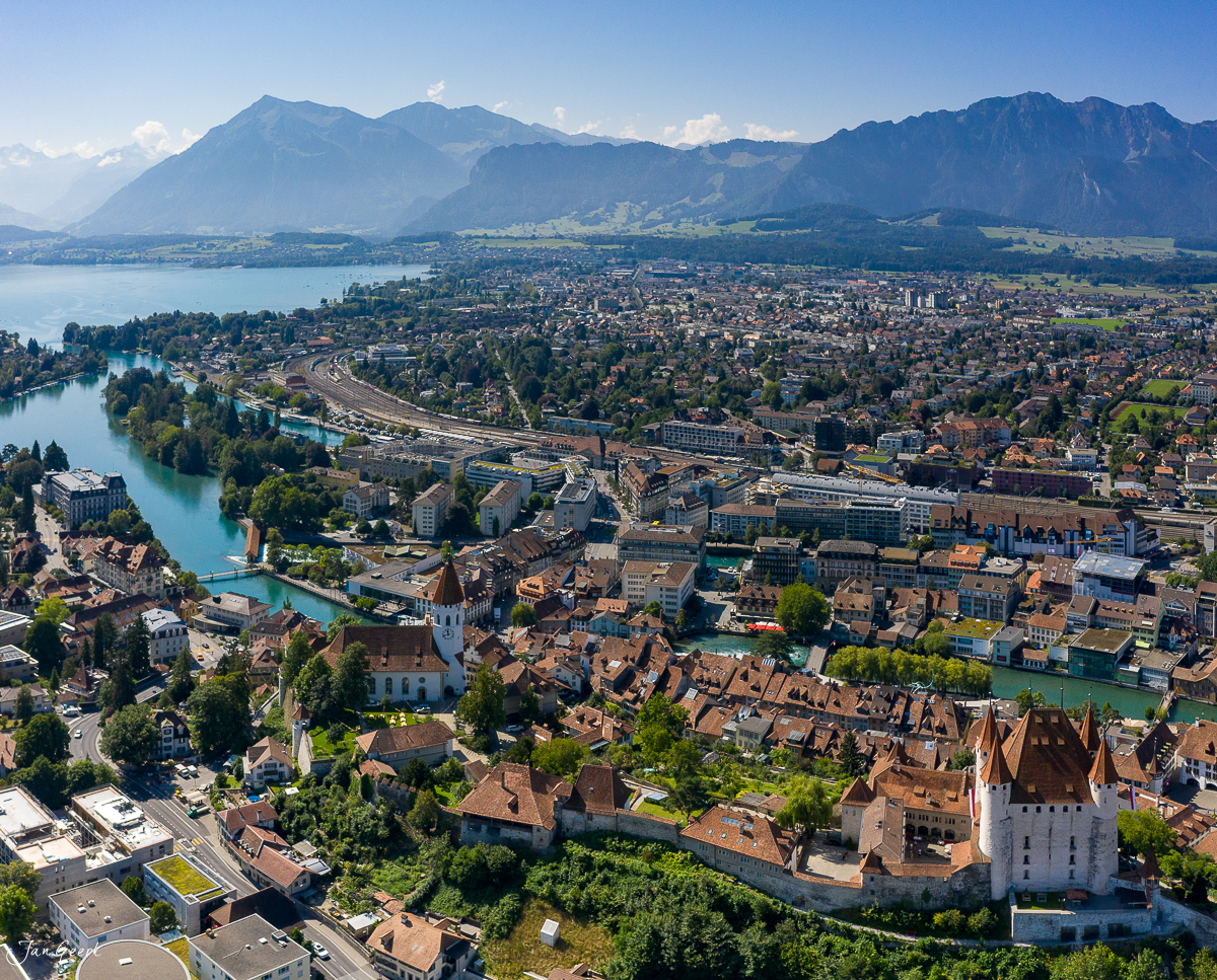 Luftaufnahme von Thun mit Schloss, Aare und Alpen im Sommer – Jan Geerk Fotograf Basel
