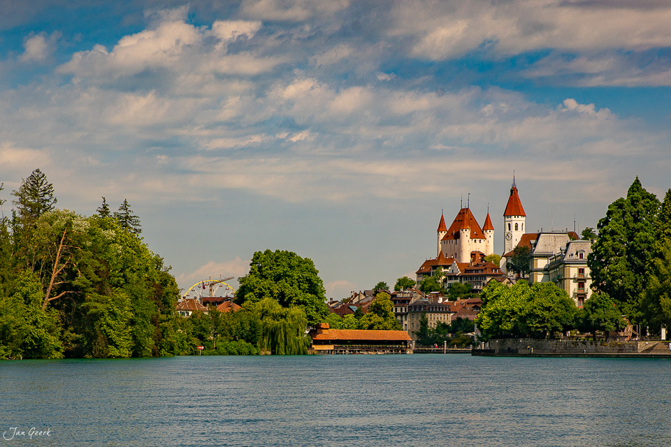 Schloss Thun am Ufer des Thunersees mit grünen Bäumen und blauem Himmel, Sommer in der Schweiz – Jan Geerk Fotograf Basel