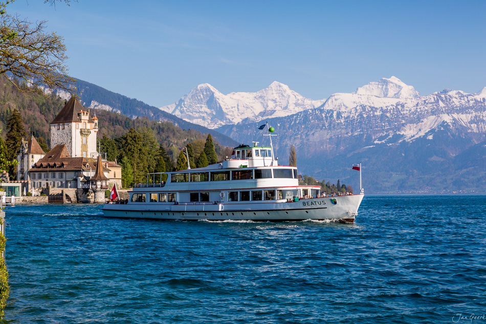 Schiff Beatus auf dem Thunersee mit Schloss Oberhofen und verschneiten Alpen im Frühling, Berner Oberland Schweiz – Jan Geerk Fotograf Basel