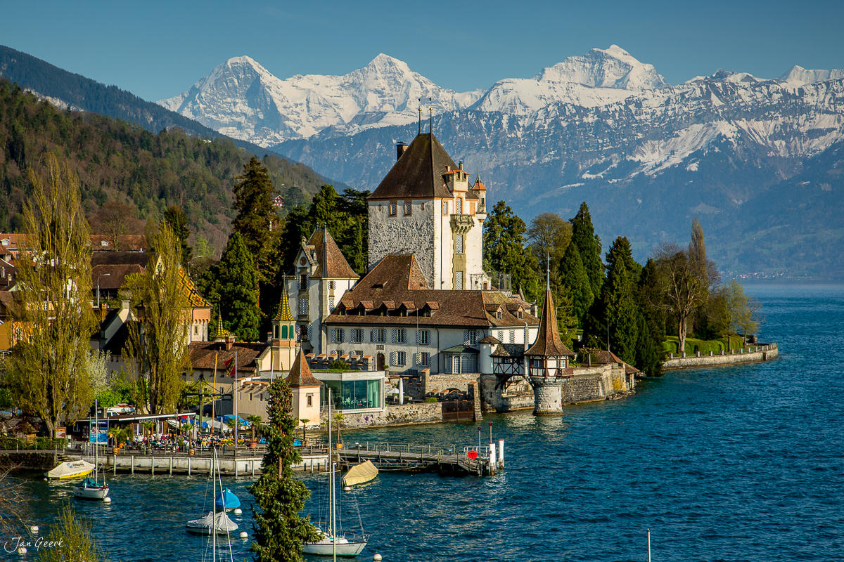 Schloss Oberhofen am Thunersee mit schneebedeckten Alpen im Hintergrund, Frühlingssonne, Berner Oberland Schweiz – Jan Geerk Fotograf Basel