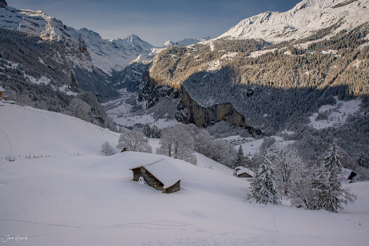 Verschneite Alphütten im Lauterbrunnental mit schneebedeckten Bergen und Staubbachfall im Winter, Berner Oberland Schweiz – Jan Geerk Fotograf Basel
