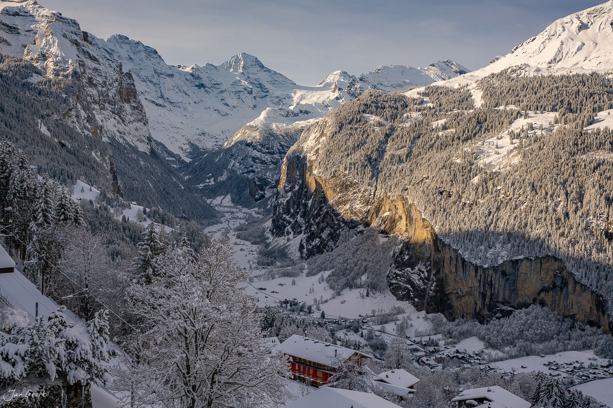Winterliches Lauterbrunnen-Tal mit schneebedeckten Bergen, Nadelwäldern und rotem Chalet in der Schweiz – Jan Geerk Fotograf Basel