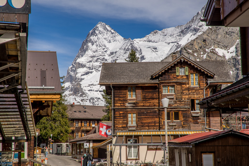 Holzchalet mit Schweizer Flagge vor schneebedecktem Berg in Mürren, Berner Oberland Schweiz – Jan Geerk Fotograf Basel