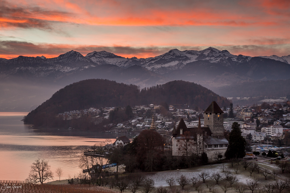 Schloss Spiez am Thunersee im Wintersonnenuntergang mit verschneiten Alpen im Hintergrund – Jan Geerk Fotograf Basel