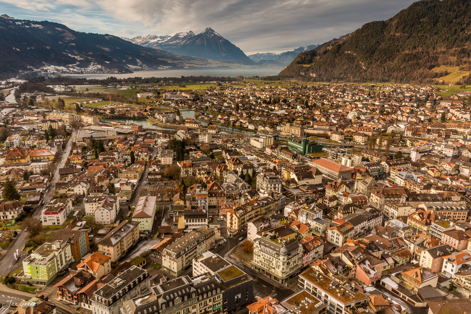 Luftaufnahme von Spiez mit Thunersee, verschneiten Alpen und winterlicher Berglandschaft in der Schweiz – Jan Geerk Fotograf Basel