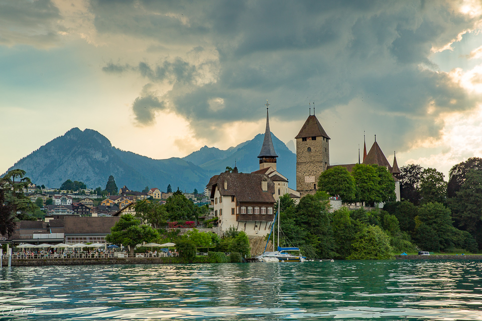 Schloss Spiez am Thunersee mit Kirchtürmen, grüne Uferlandschaft und Bergpanorama bei Sommerlichtstimmung, Berner Oberland Schweiz – Jan Geerk Fotograf Basel