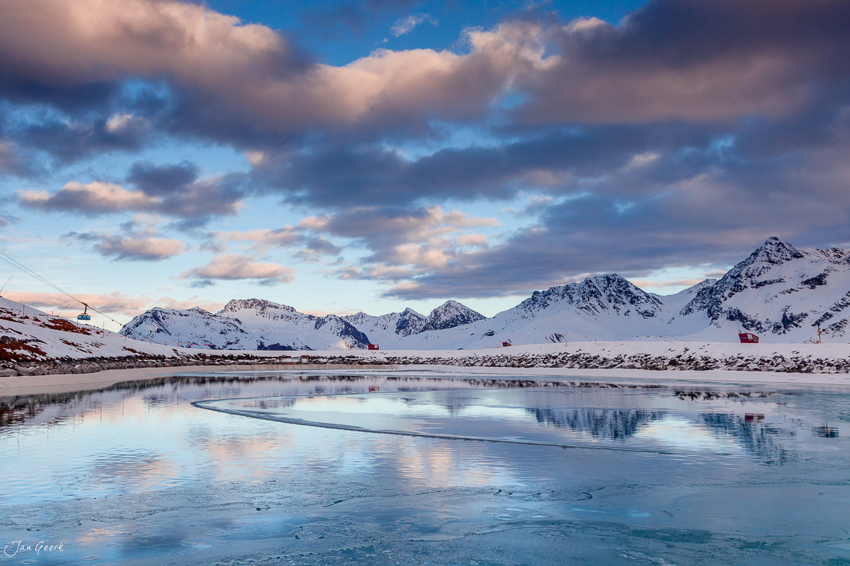 Gefrorener See mit schneebedeckten Bergen bei Sonnenuntergang in Arosa Graubünden Schweiz – Jan Geerk Fotograf Basel