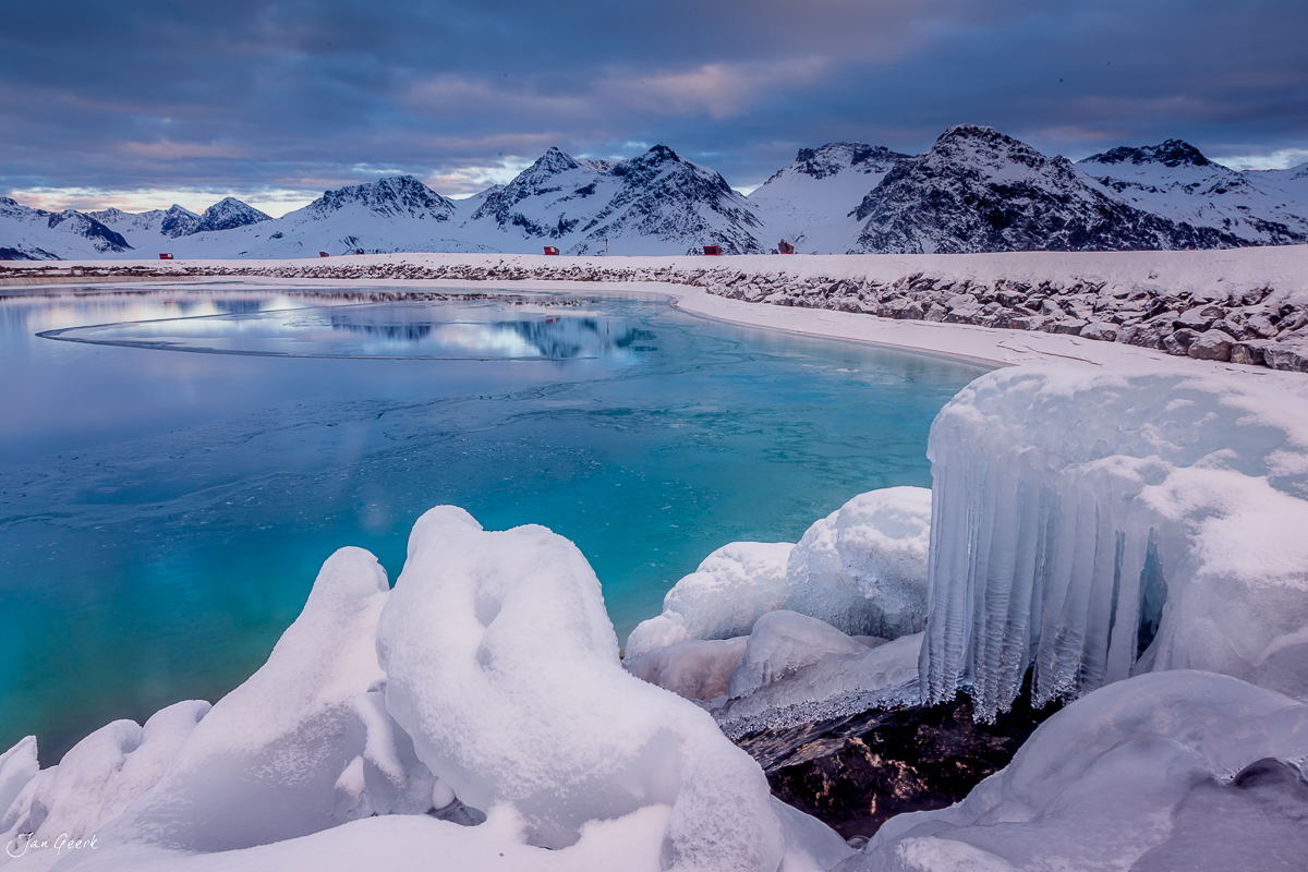 Gefrorener See mit Eisformationen und schneebedeckten Bergen, Arosa Winter Graubünden Schweiz – Jan Geerk Fotograf Basel