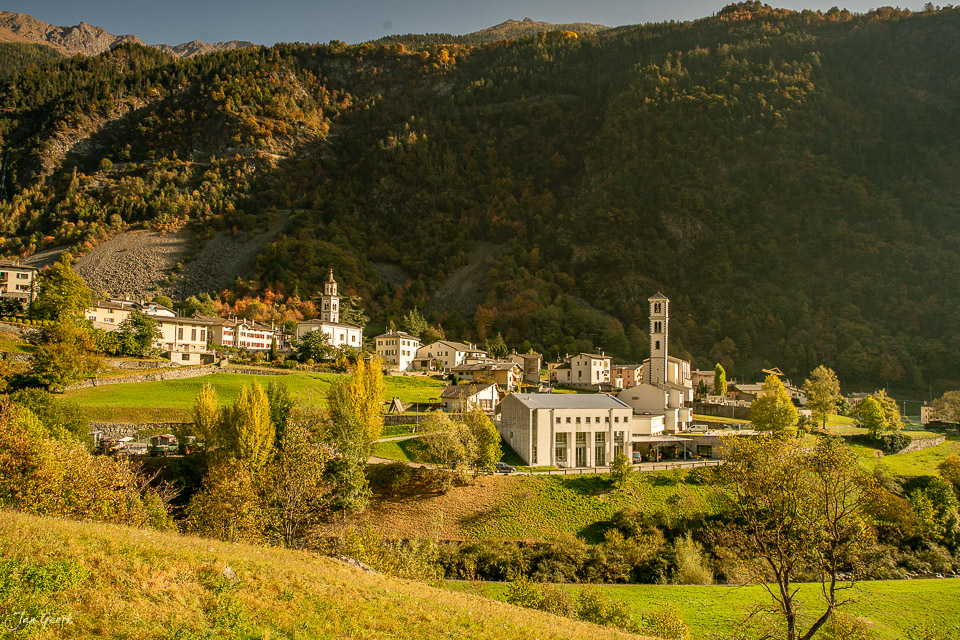 Dorfansicht Brusio mit Kirchturm und Herbstwald in Graubünden Schweiz – Jan Geerk Fotograf Basel