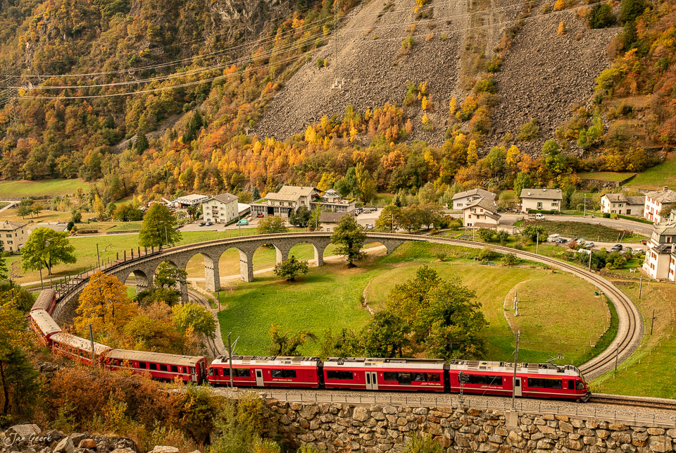 Kreisviadukt Brusio mit rotem Zug der Rhätischen Bahn im Herbst, Graubünden Schweiz – Jan Geerk Fotograf Basel