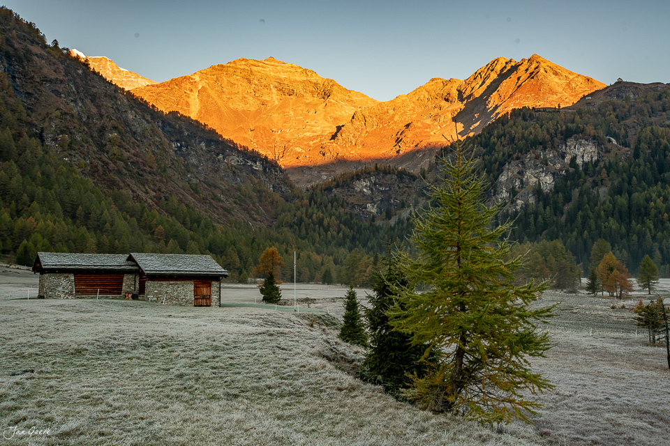 Berghütten und Lärchen im Gletschergarten Cavaglia bei Herbstsonnenaufgang, Puschlav Graubünden Schweiz – Jan Geerk Fotograf Basel