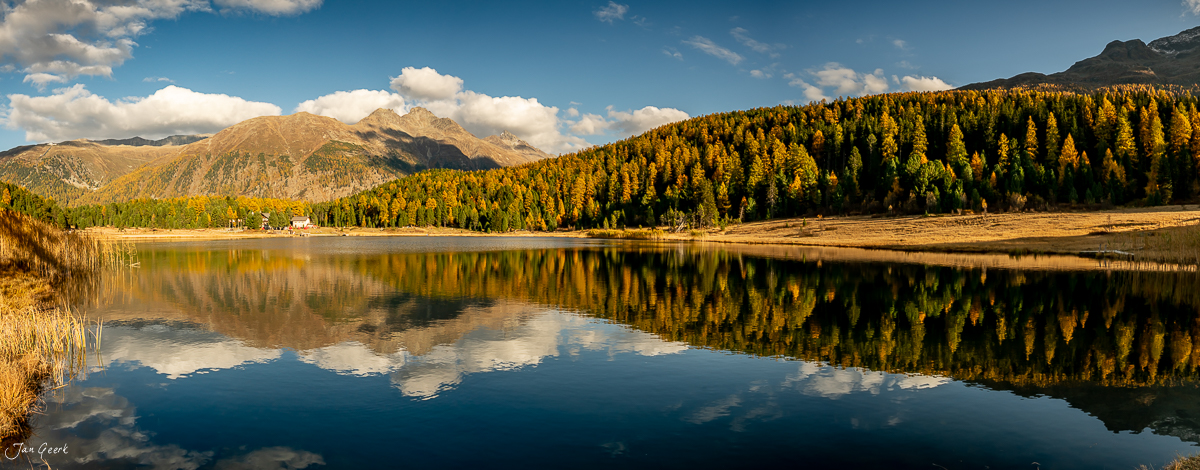 Bergsee mit Lärchenwald und Bergspiegelung im goldenen Herbstlicht Engadin Graubünden Schweiz – Jan Geerk Fotograf Basel