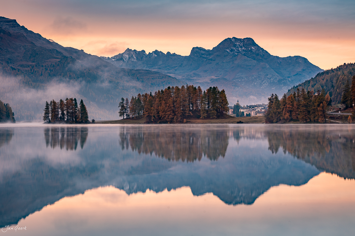 Spiegelglatter See mit Herbstwald und schneebedeckten Bergen im Engadin, Graubünden Schweiz – Jan Geerk Fotograf Basel