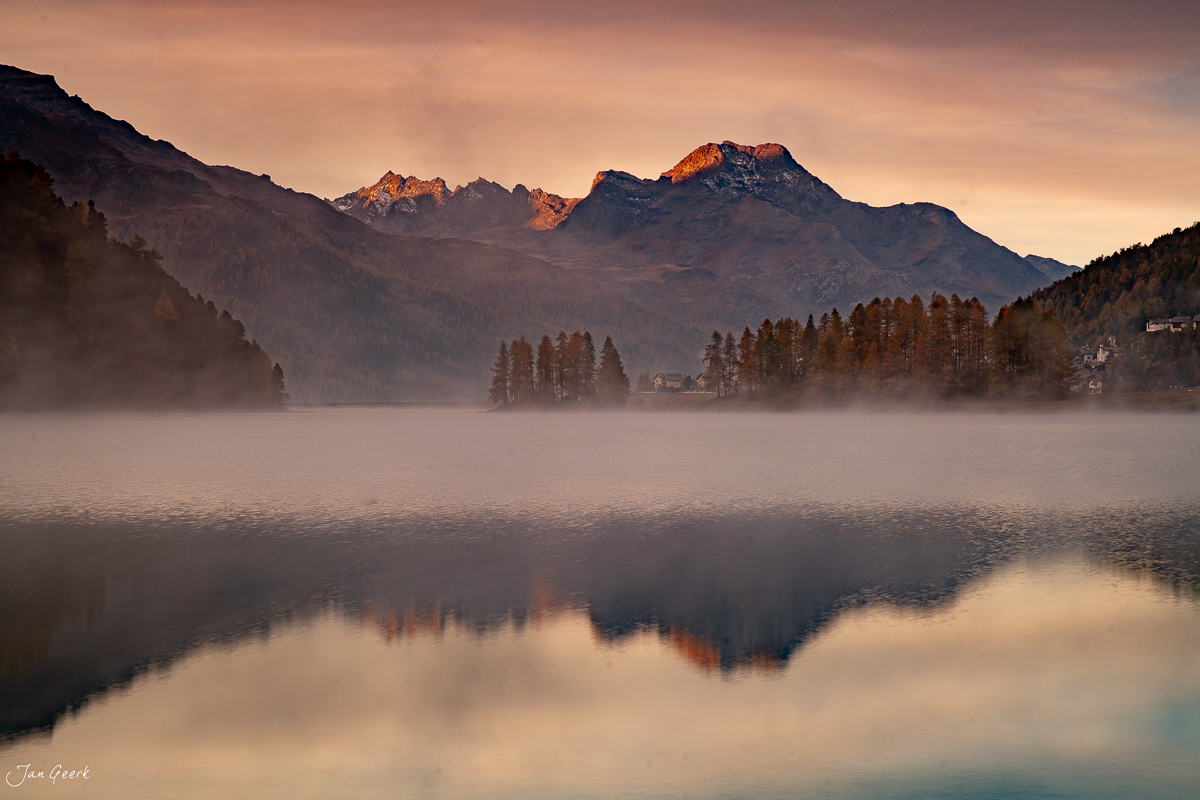 Nebel über dem See in der Engadin Region mit schneebedeckten Bergen bei Sonnenaufgang Schweiz Jan Geerk Fotograf Basel