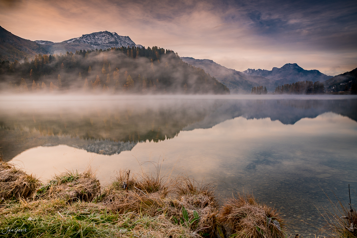 Bergsee mit Nebel und Spiegelung, schneebedeckte Gipfel im Hintergrund, Herbst im Engadin Graubünden Schweiz – Jan Geerk Fotograf Basel