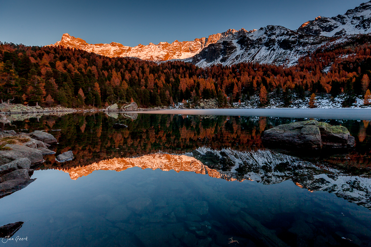 Herbstliche Lärchenwälder spiegeln sich im Lago di Saoseo Engadin Graubünden Schweiz Jan Geerk Fotograf Basel