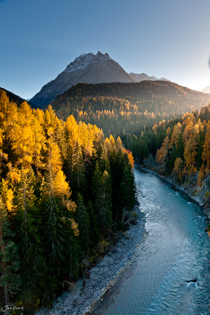 Herbstliche Lärchenwälder mit Fluss und Berggipfel Engadin Graubünden Oktober Schweiz Jan Geerk Fotograf