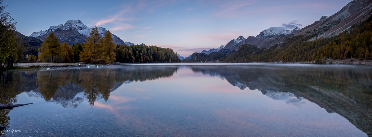 Spiegelglatter Bergsee im Engadin mit schneebedeckten Alpengipfeln, goldenen Lärchen und herbstlicher Morgenstimmung in Graubünden Schweiz – Jan Geerk Fotograf Basel