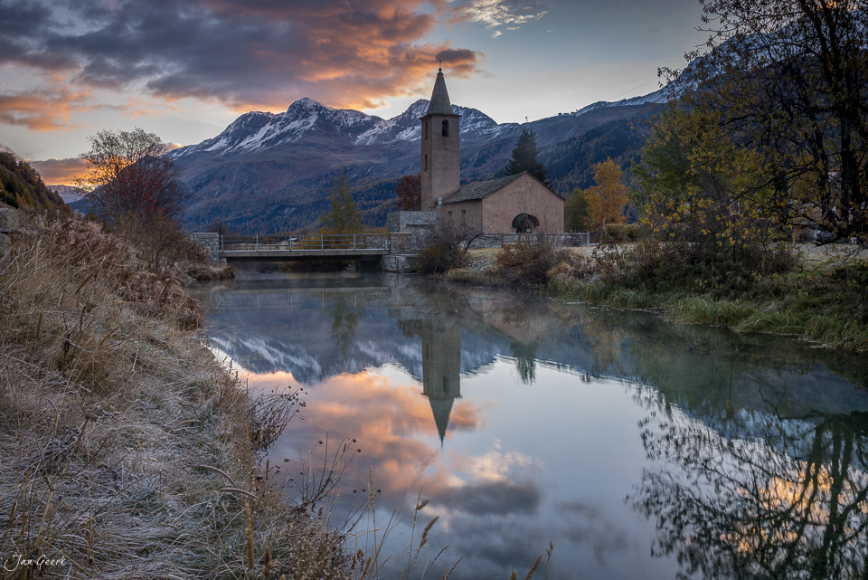Kirche Morteratsch mit Spiegelung im Fluss, Herbststimmung, Engadin Graubünden Schweiz – Jan Geerk Fotograf Basel