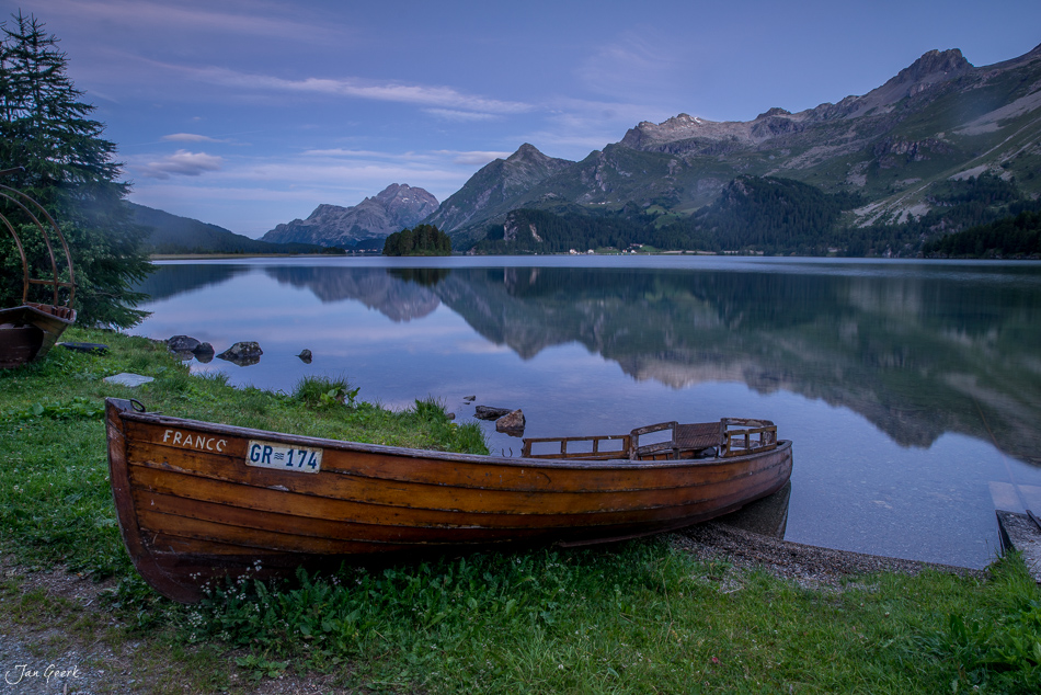 Holzboot am Ufer des Silsersees mit Bergspiegelung, Engadin Graubünden Schweiz – Jan Geerk Fotograf Basel