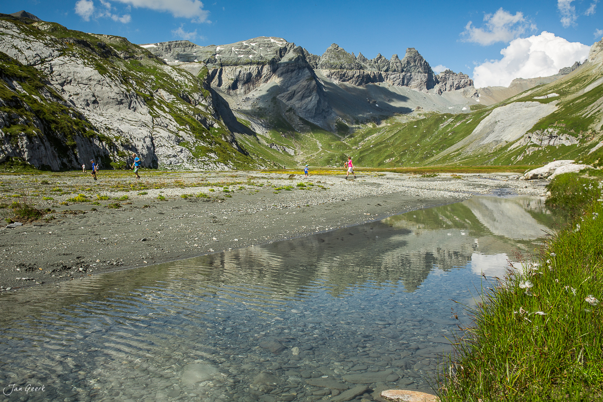 Wanderer an kristallklarem Bergsee in Segnesboden mit Tschingelhörnern, Sommer in Graubünden Schweiz – Jan Geerk Fotograf Basel