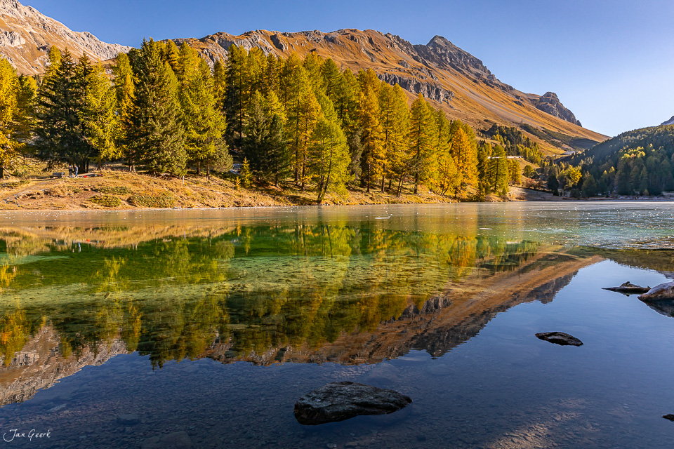 Alpensee mit herbstlichen Lärchen und Bergspiegelung, Palpuognasee Graubünden Schweiz – Jan Geerk Fotograf Basel
