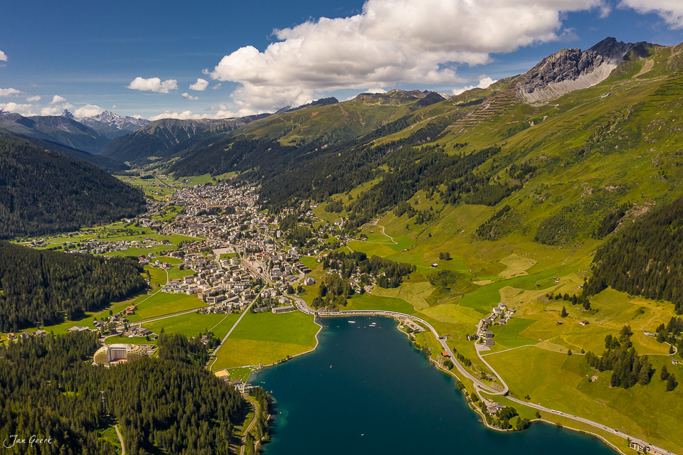 Luftaufnahme Davos mit Davosersee, grünen Alpenwiesen, Sommerlichtstimmung, Graubünden Schweiz – Jan Geerk Fotograf Basel