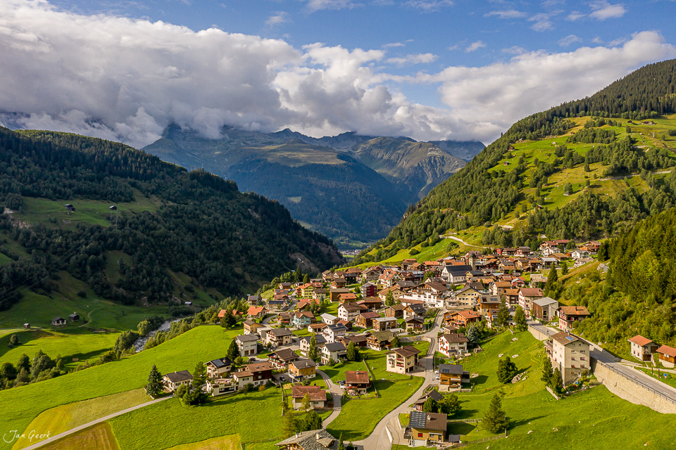 Luftaufnahme Disentis Bergdorf grüne Alpenlandschaft Sommer Graubünden Schweiz Jan Geerk Fotograf Basel