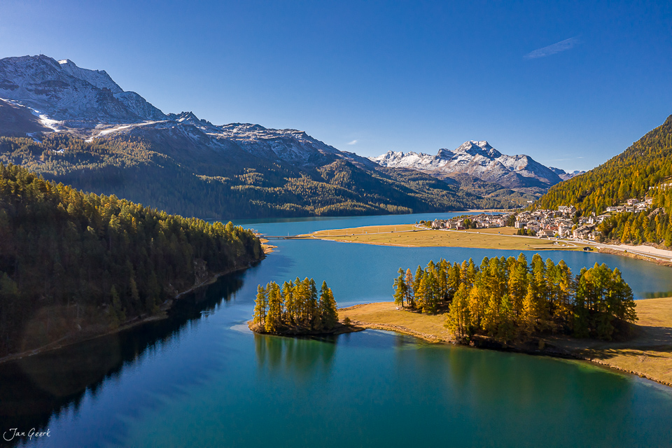 Alpiner See mit Lärchenwäldern im Herbst, schneebedeckte Berge, klarer Himmel, Engadin Graubünden Schweiz – Jan Geerk Fotograf Basel