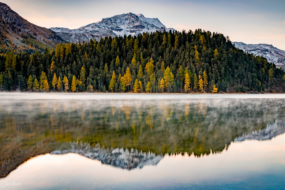 Spiegelglatter See mit Lärchenwäldern in Herbstfarben und schneebedeckten Bergen, Engadin Graubünden Schweiz – Jan Geerk Fotograf Basel
