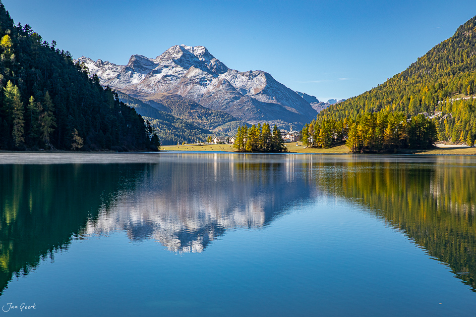 Spiegelglatte Seefläche am Champfersee mit schneebedecktem Berg, Nadelwälder und klarer Himmel, Engadin Graubünden Schweiz – Jan Geerk Fotograf Basel