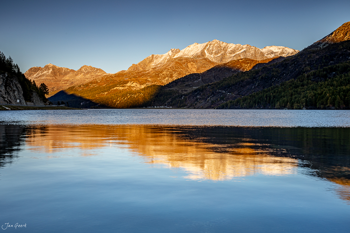 Alpensee mit Spiegelung verschneiter Berggipfel bei Sonnenaufgang, Engadin Graubünden Schweiz – Jan Geerk Fotograf Basel