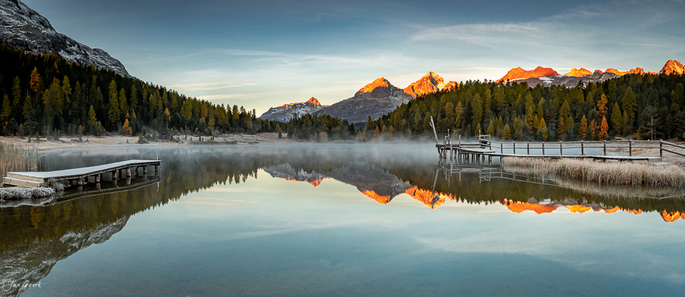 Stazersee mit Spiegelung verschneiter Berggipfel im goldenen Herbstlicht, Graubünden Schweiz – Jan Geerk Fotograf Basel