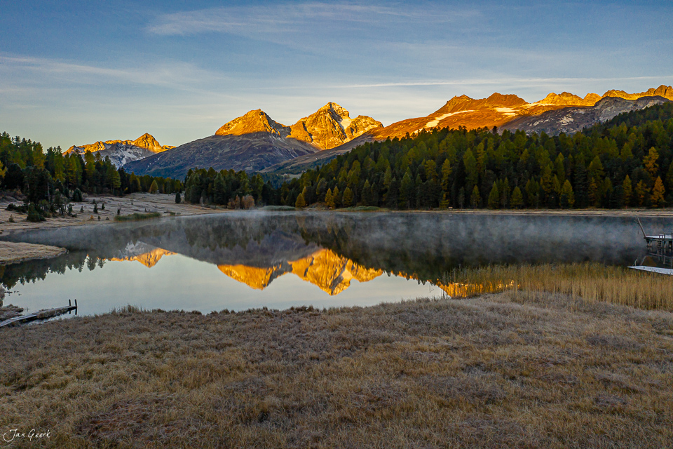 Spiegelung der golden beleuchteten Berggipfel im Stazersee während der Herbststimmung in Graubünden Schweiz – Jan Geerk Fotograf Basel
