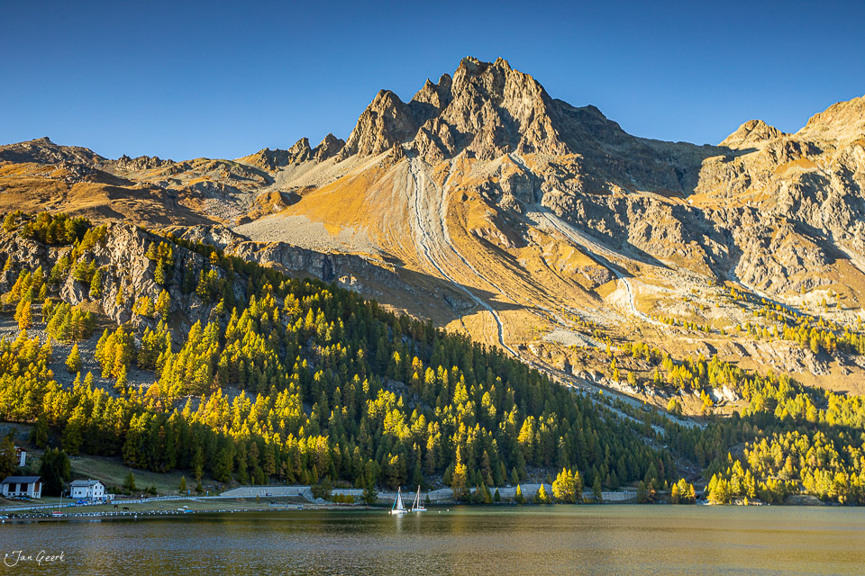 Alpensee mit Lärchenwäldern und Bergpanorama im Herbst, Engadin Graubünden Schweiz – Jan Geerk Fotograf Basel