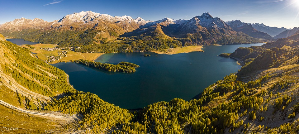 Silsersee mit schneebedeckten Berggipfeln, Lärchenwäldern in Herbstfarben und alpiner Berglandschaft in Graubünden Schweiz – Jan Geerk Fotograf Basel