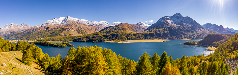 Alpensee mit schneebedeckten Gipfeln, Lärchenwald im Herbst, Graubünden Schweiz – Jan Geerk Fotograf Basel