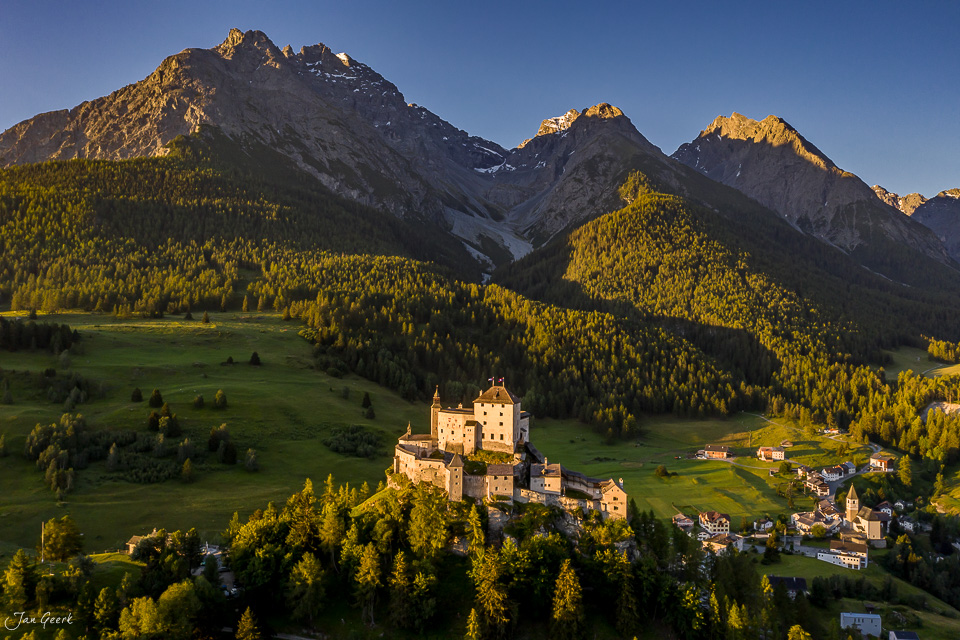 Schloss Tarasp in herbstlicher Lärchengolden-Stimmung, umgeben von grünen Almwiesen und Engadin-Bergen, Graubünden Schweiz – Jan Geerk Fotograf Basel
