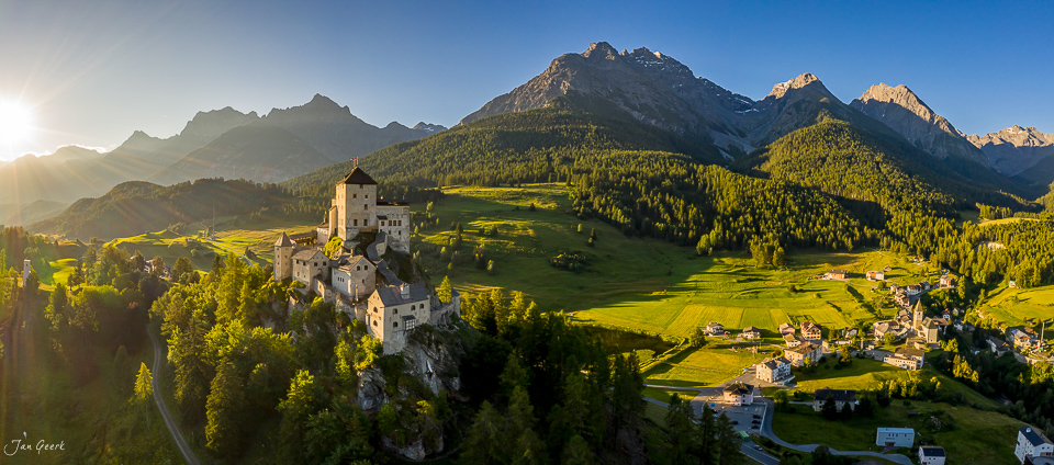 Schloss Tarasp auf Felsklippe mit Engadin Alpental, grüne Sommerwiesen und Berggipfel im Kantlicht, Graubünden Schweiz – Jan Geerk Fotograf Basel