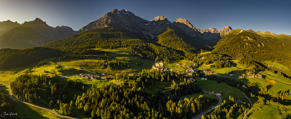 Luftaufnahme Schloss Tarasp umgeben von grünen Wiesen und Wäldern, Sommerlichtstimmung, Unterengadin Graubünden Schweiz – Jan Geerk Fotograf Basel