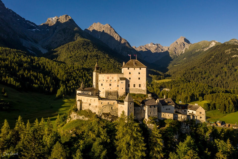 Schloss Tarasp in der Engadin Sommerlandschaft mit Lärchenwäldern und Bergen Schweiz Jan Geerk Fotograf Basel